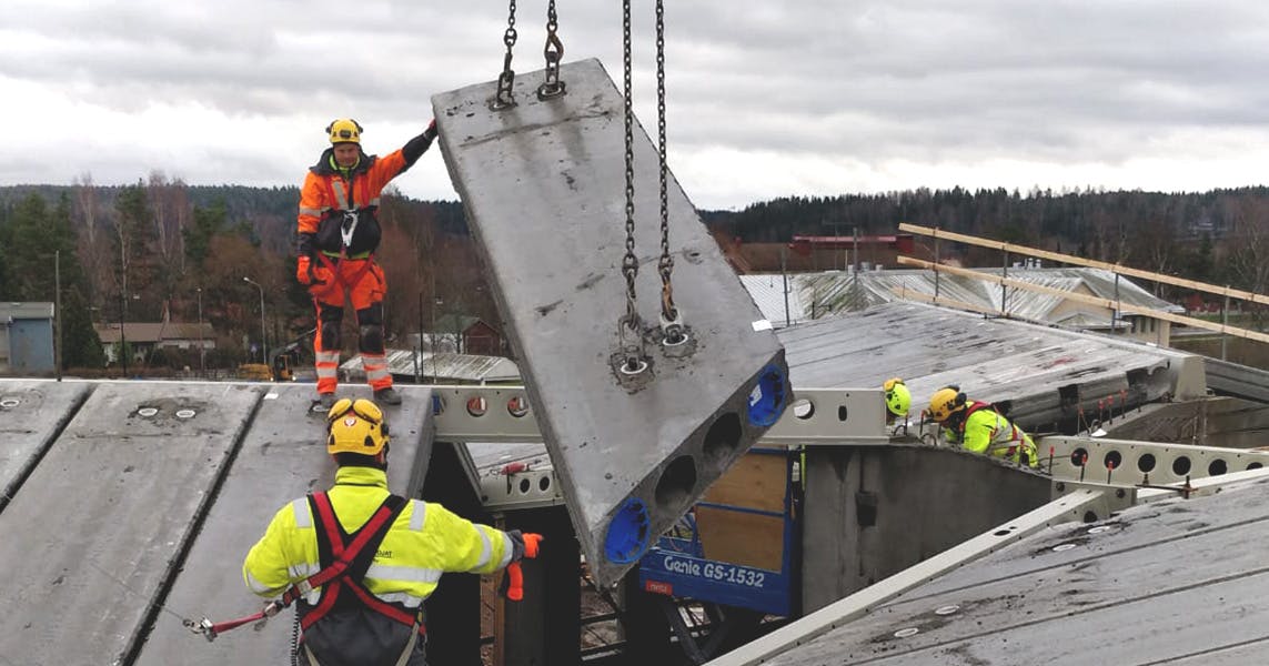 Betonielementtiasentajat nostamassa isoa betonielemnettiä rakennustyömaalla