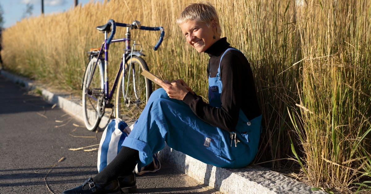 Woman reading a book, enjoying a break from riding her bike