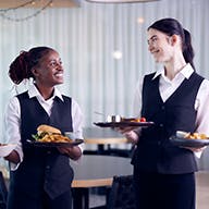 Two waiters smiling at each other