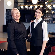 Two employees smiling at the camera together