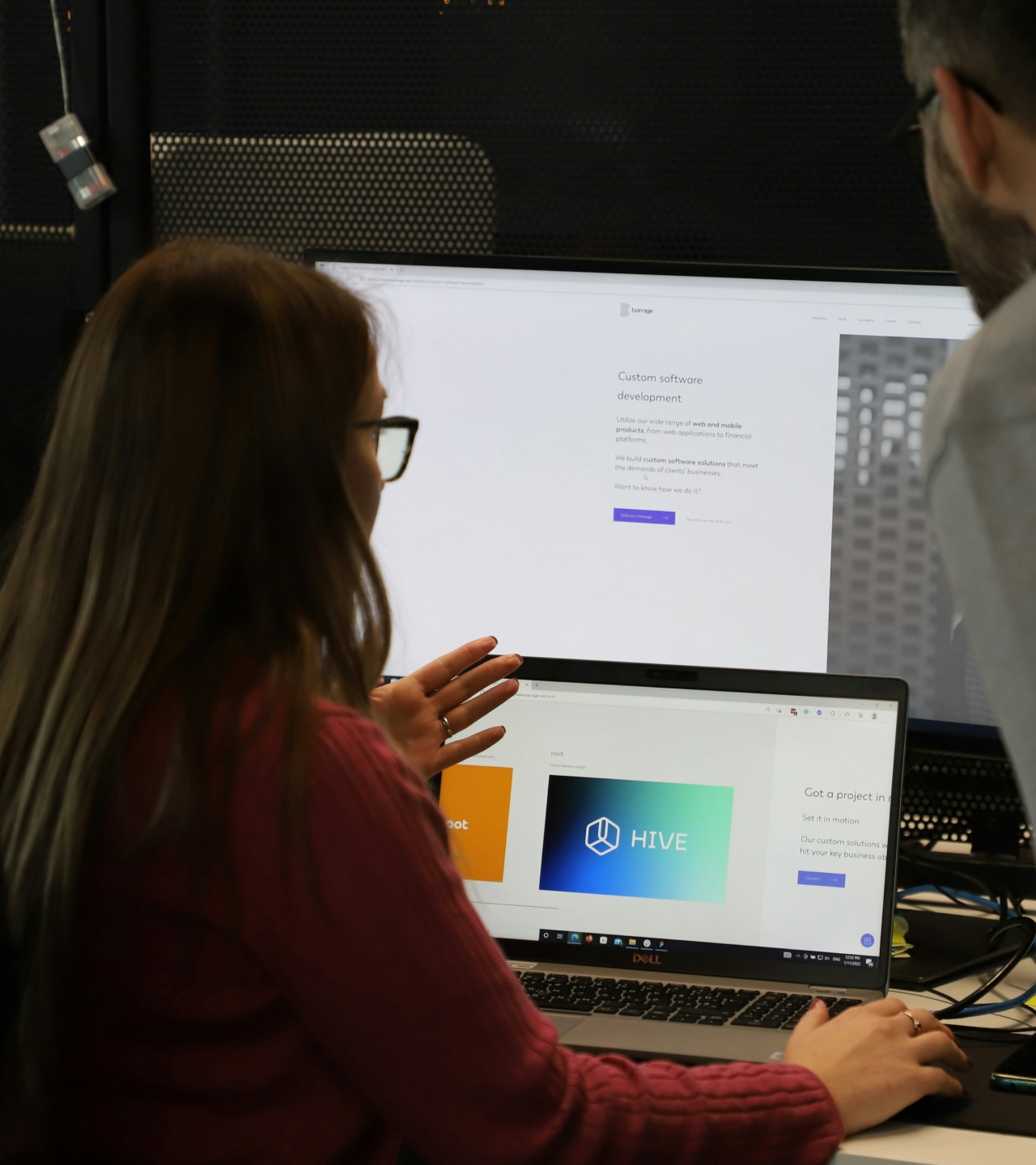 A man and a woman looking at two screens