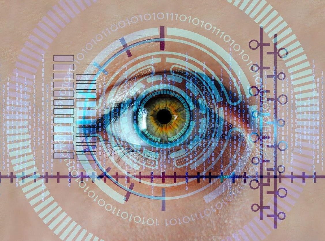 Auf dem Bild ist ein Auge zu sehen, wie es durch einen biometrischen Scanner gescannt wird.