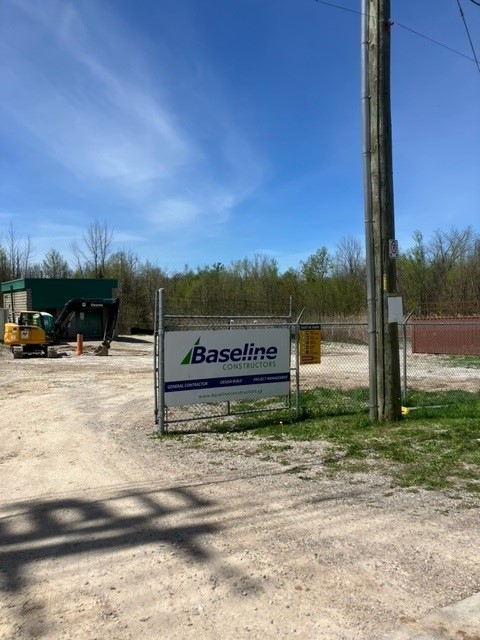 Baseline Constructors Inc. construction signage attached to the front chain link fence gate