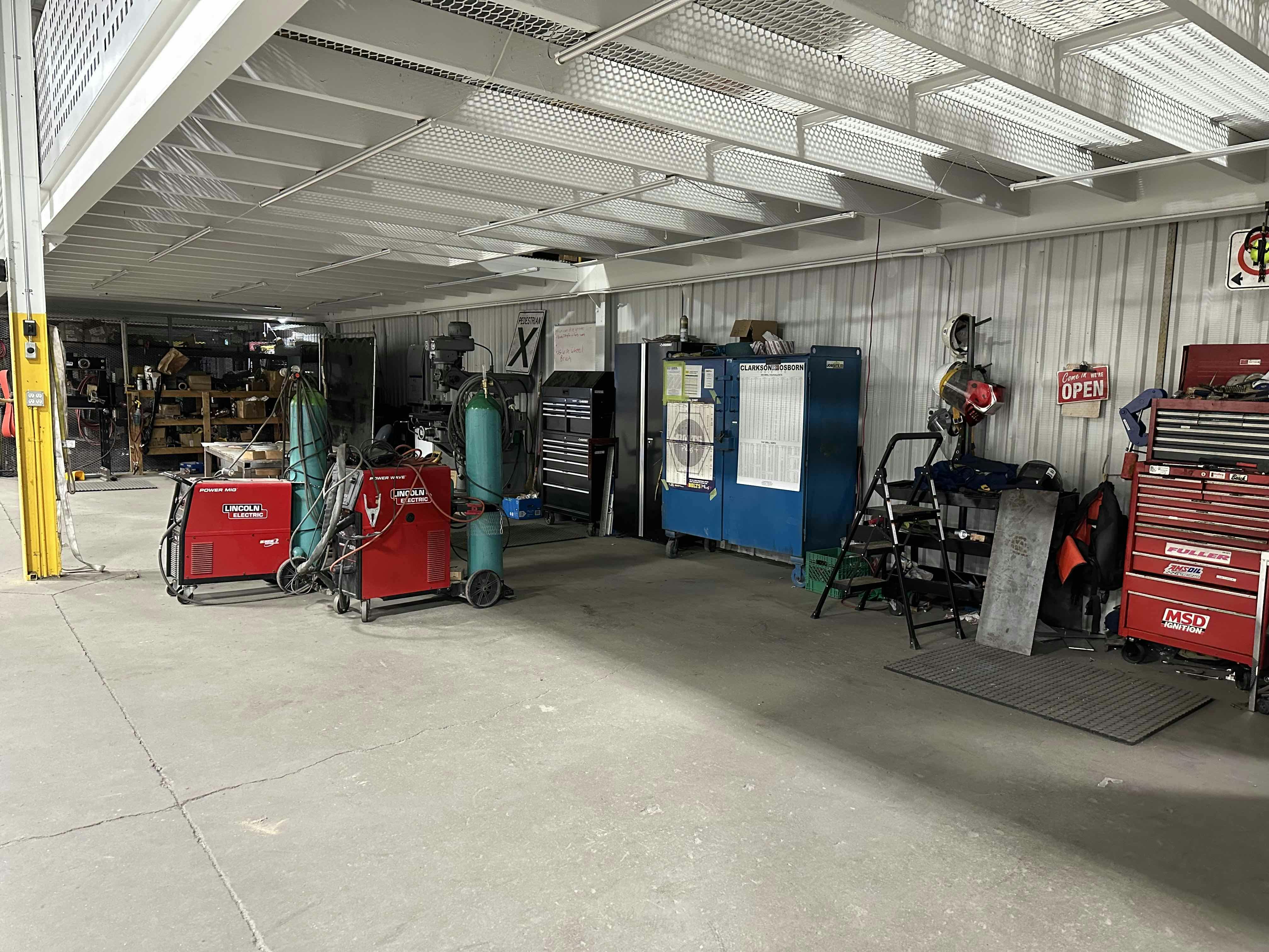 Interior view of a workshop at Colby Drive with various tools, equipment, and storage cabinets