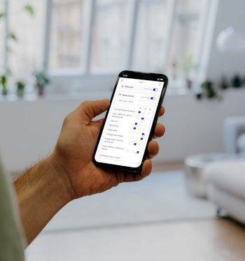 Person standing, engaged with Batmaid app displaying checklist feature.