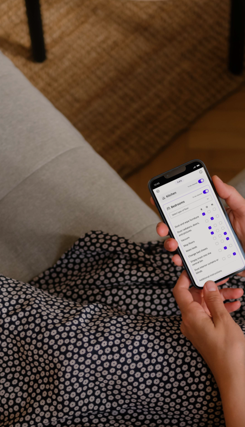 Person relaxed on sofa, exploring Batmaid app with checklist feature open.