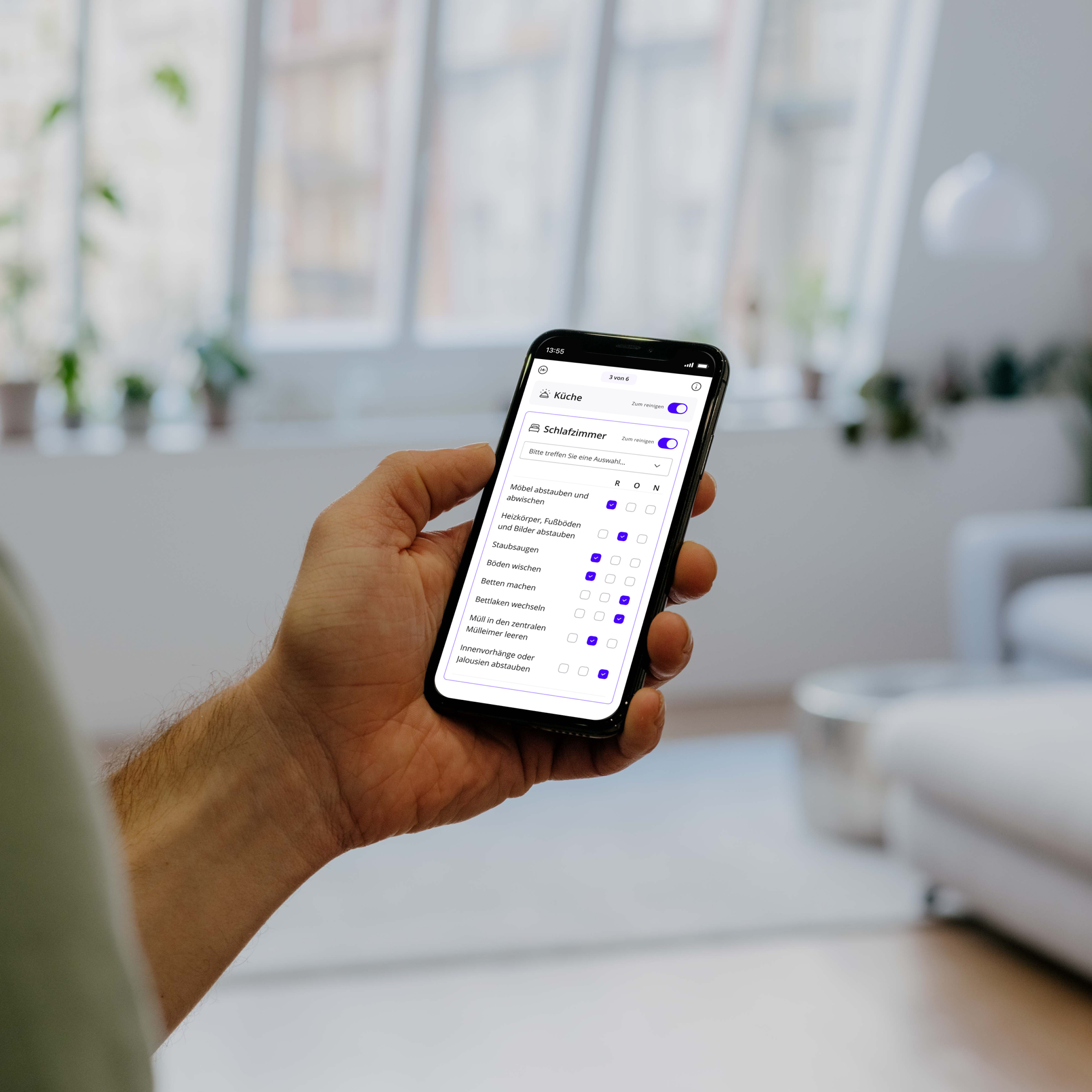Person steht und nutzt die Batmaid-App mit der Checklistenfunktion.