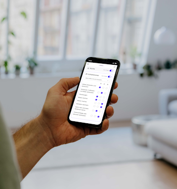 Person steht und nutzt die Batmaid-App mit der Checklistenfunktion.
