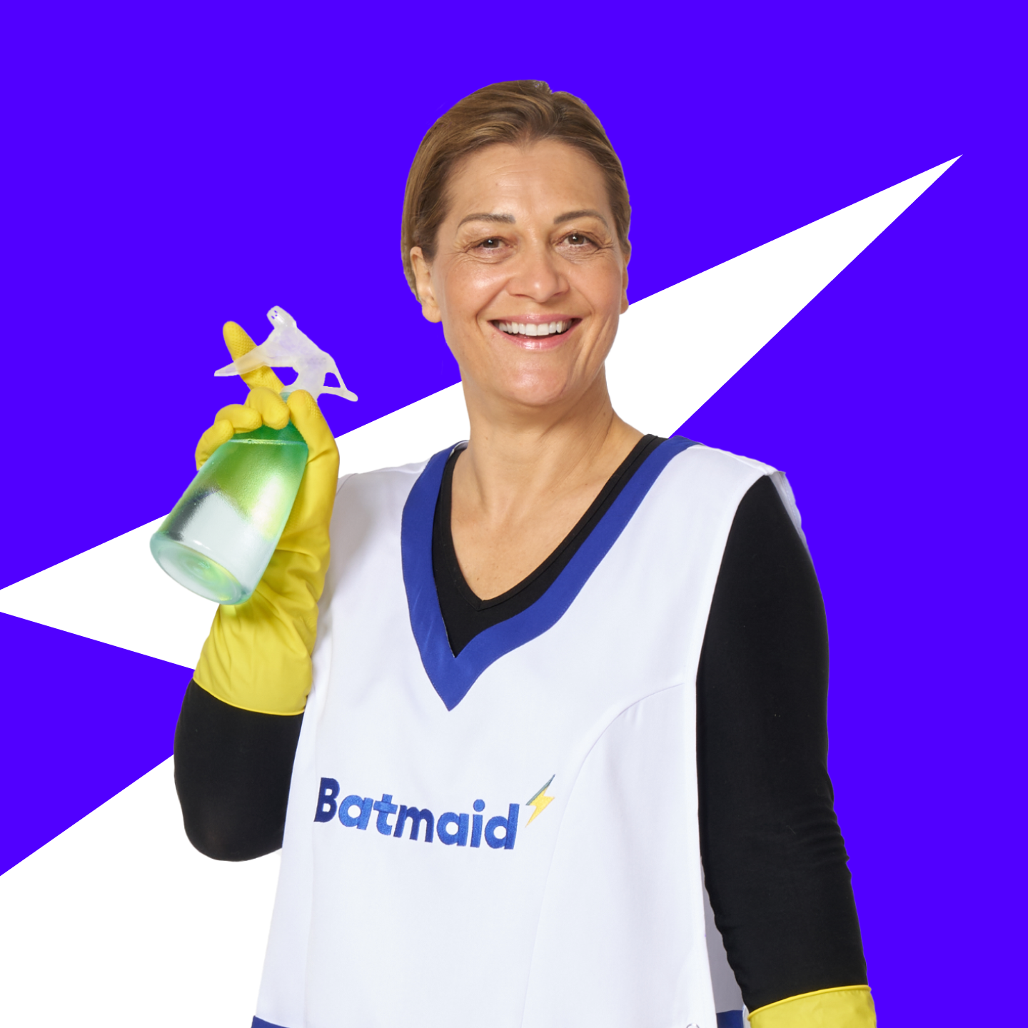 Portrait of a smiling employed cleaner wearing a Batmaid apron, confidently posing against a dark blue background