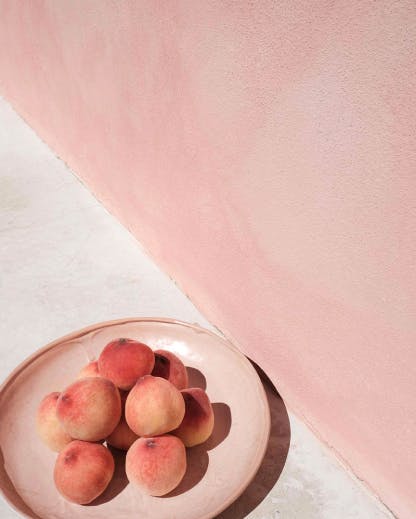 a cement rendered wall painted with a peach coloured lime wash finish by BAUWERK Colour  