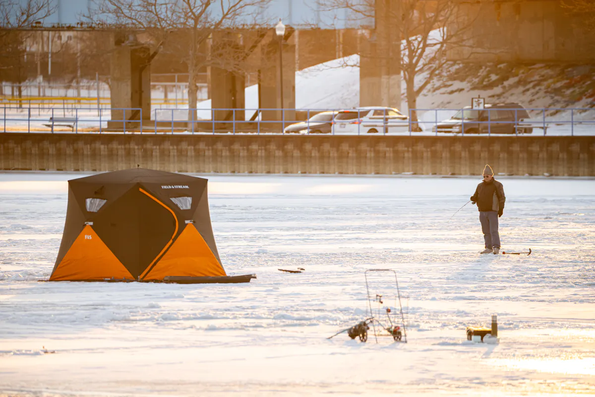 Man ice fishing on the Saginaw River in Bay City, Michigan