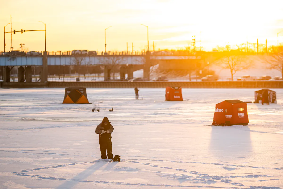Man ice fishing on the Saginaw River in Bay City, Michigan