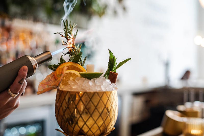 A bartender at The Public House in Bay City making a drink called "Birds in the Trap"