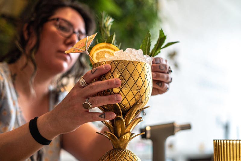 A bartender at The Public House in Bay City making a drink called "Birds in the Trap"