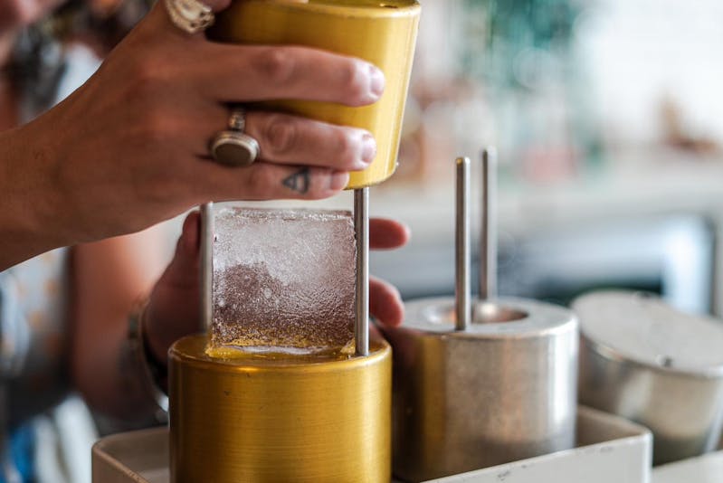 A bartender at The Public House in Bay City making a drink called "Moon Over Mexico"