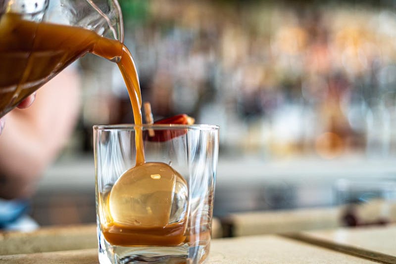 A bartender at The Public House in Bay City making a drink called "Moon Over Mexico"