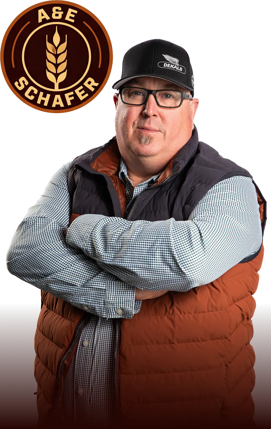 Circular badge with a wheat stalk icon in the center, surrounded by the words “A&E Schaefer” in a brown and gold color palette beside a photo of Ed Schafer with his arms crossed