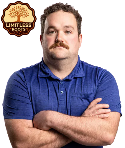 Rounded emblem with a stylized tree and spreading roots, labeled “Limitless Roots,” in earthy brown and orange tones beside a photo of Lucas Saunders with his arms crossed