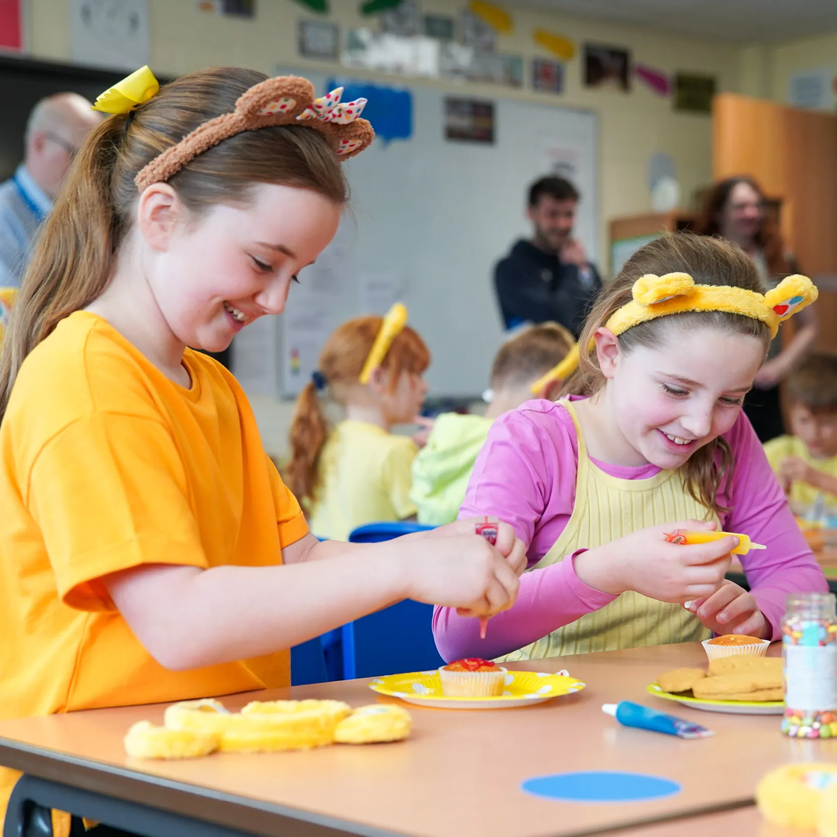 Schoolchildren doing crafts wearing Pudsey ears.