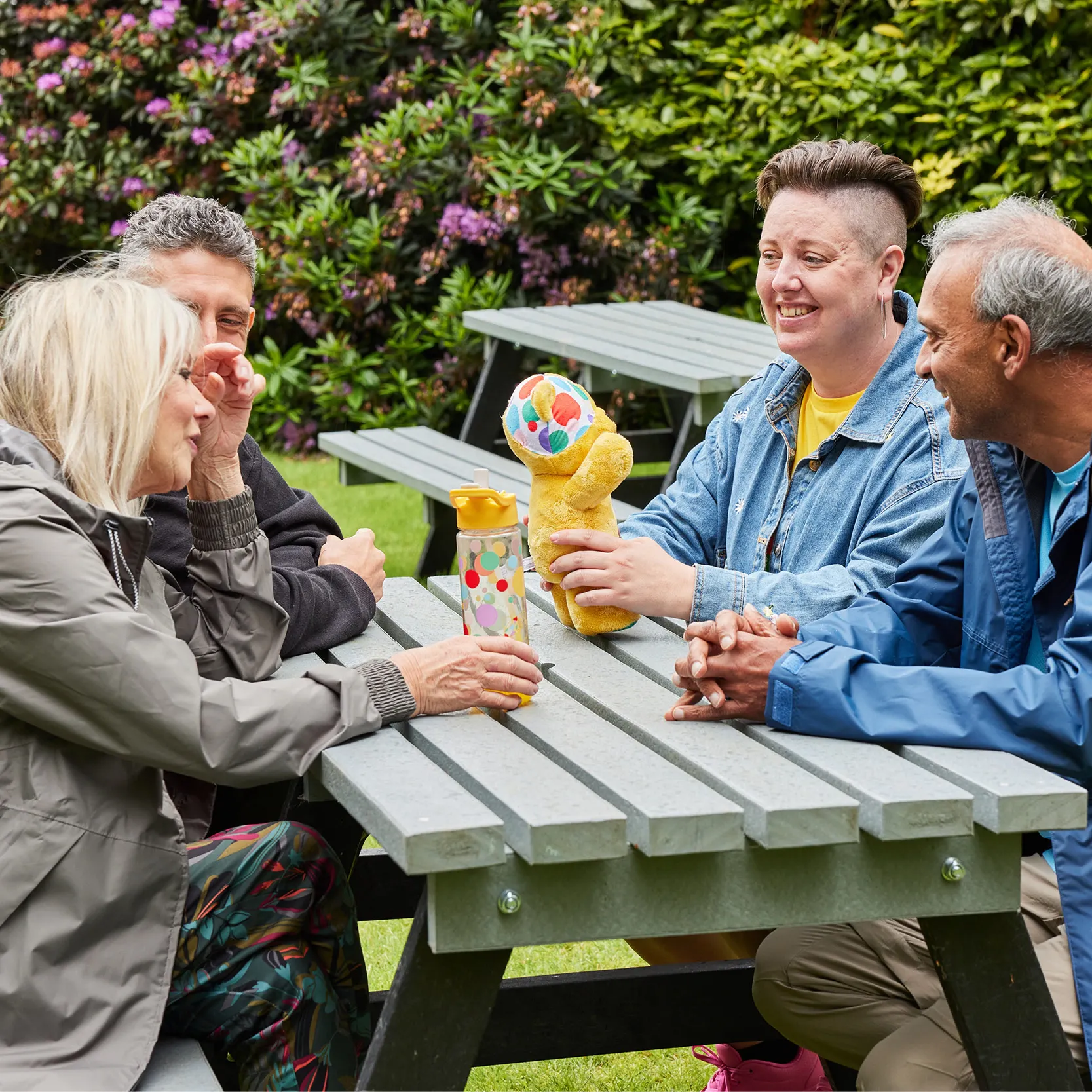 Group of adults sitting at a picnic table.