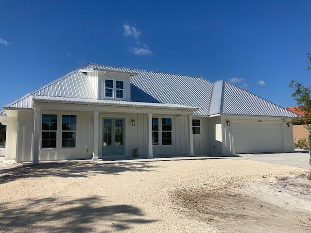 Modern white coastal farmhouse with metal roof