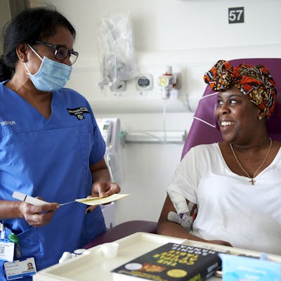 Photo of a nurse and patient smiling at one another.