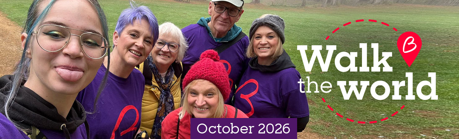 Group of participants posing on a misty park walk, promoting Walk the World in October 2026.