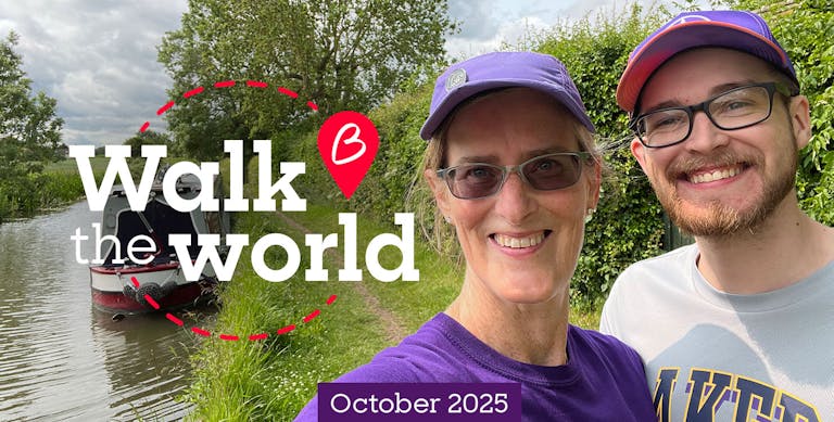 Two people smiling in front of a canal.