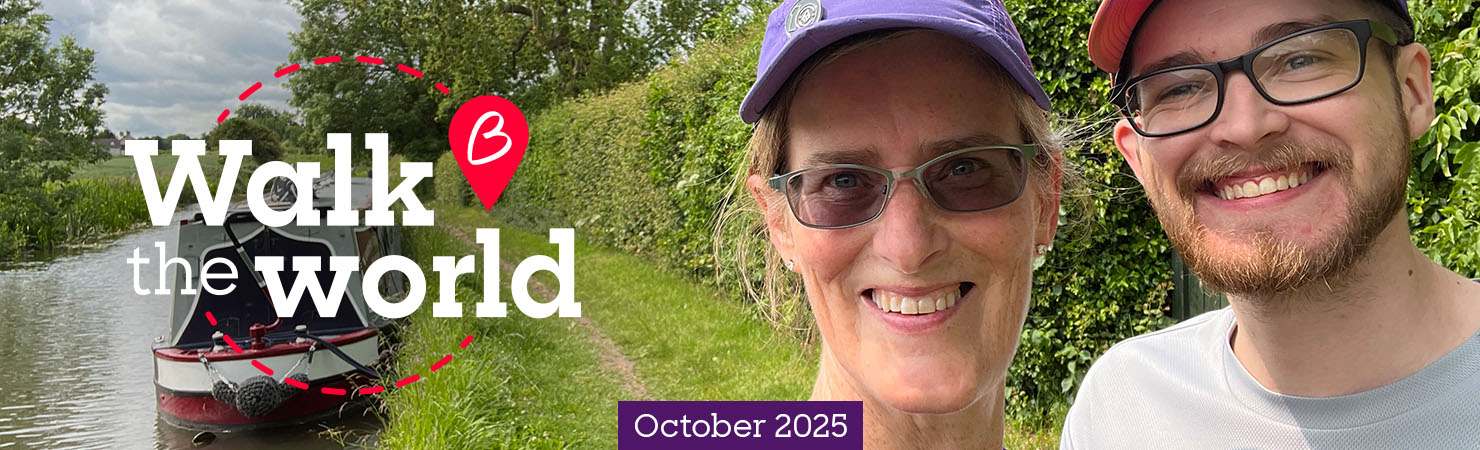 Two people smiling in front of a canal.