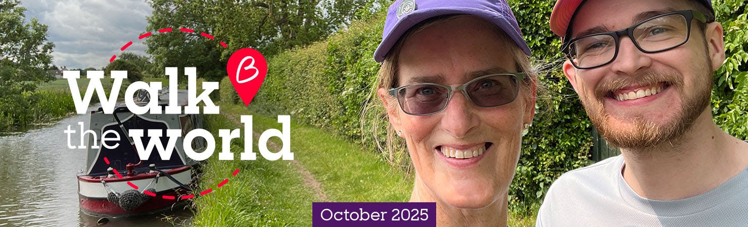Two people smiling in front of a canal.