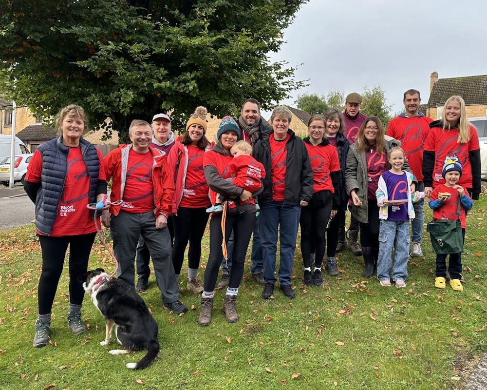 Group of people and pets smiling outside in Blood Cancer UK t-shirts.