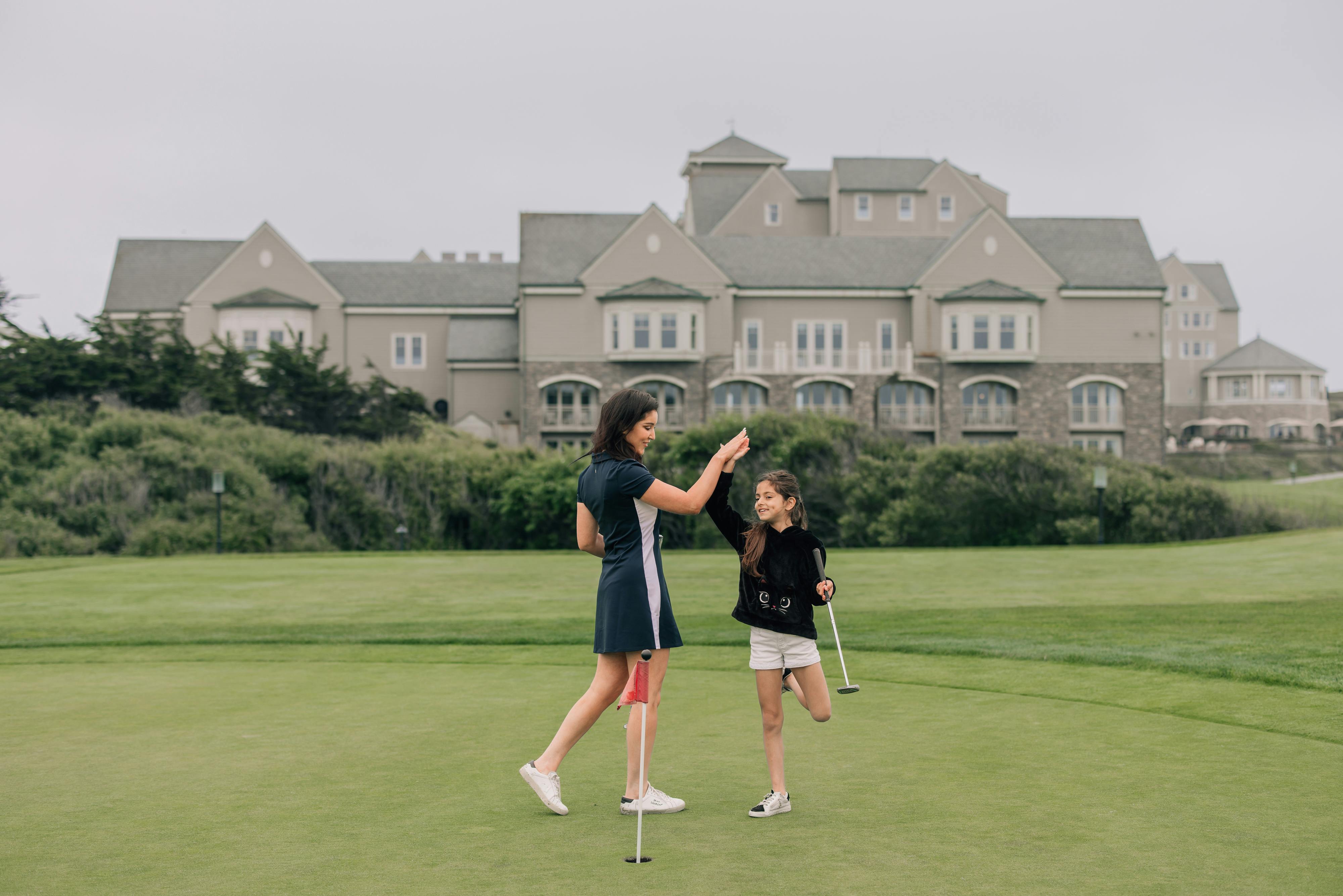girls high fiving on a golf resort