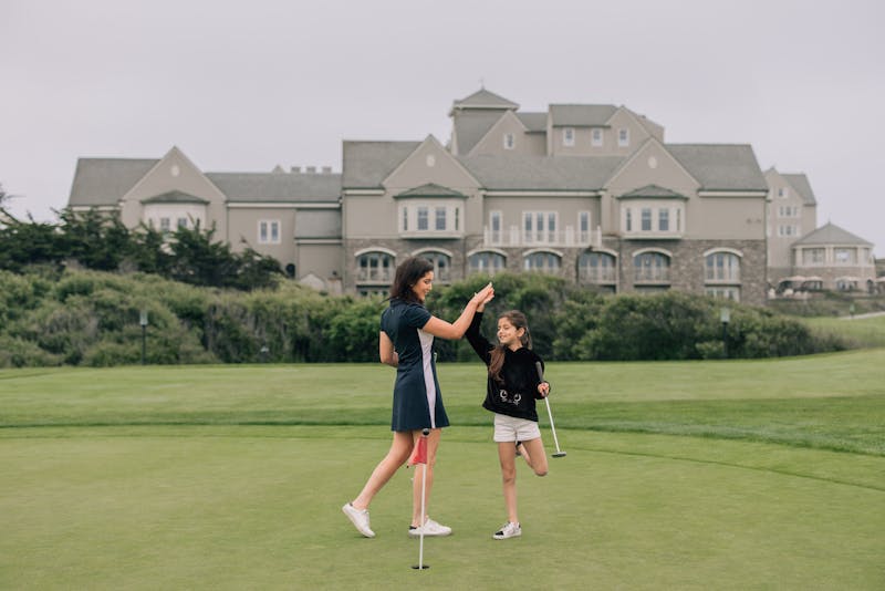 girls high fiving on a golf resort