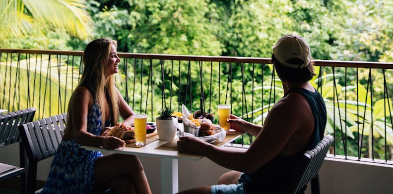 couple eating breakfast overlooking a jungle landscape