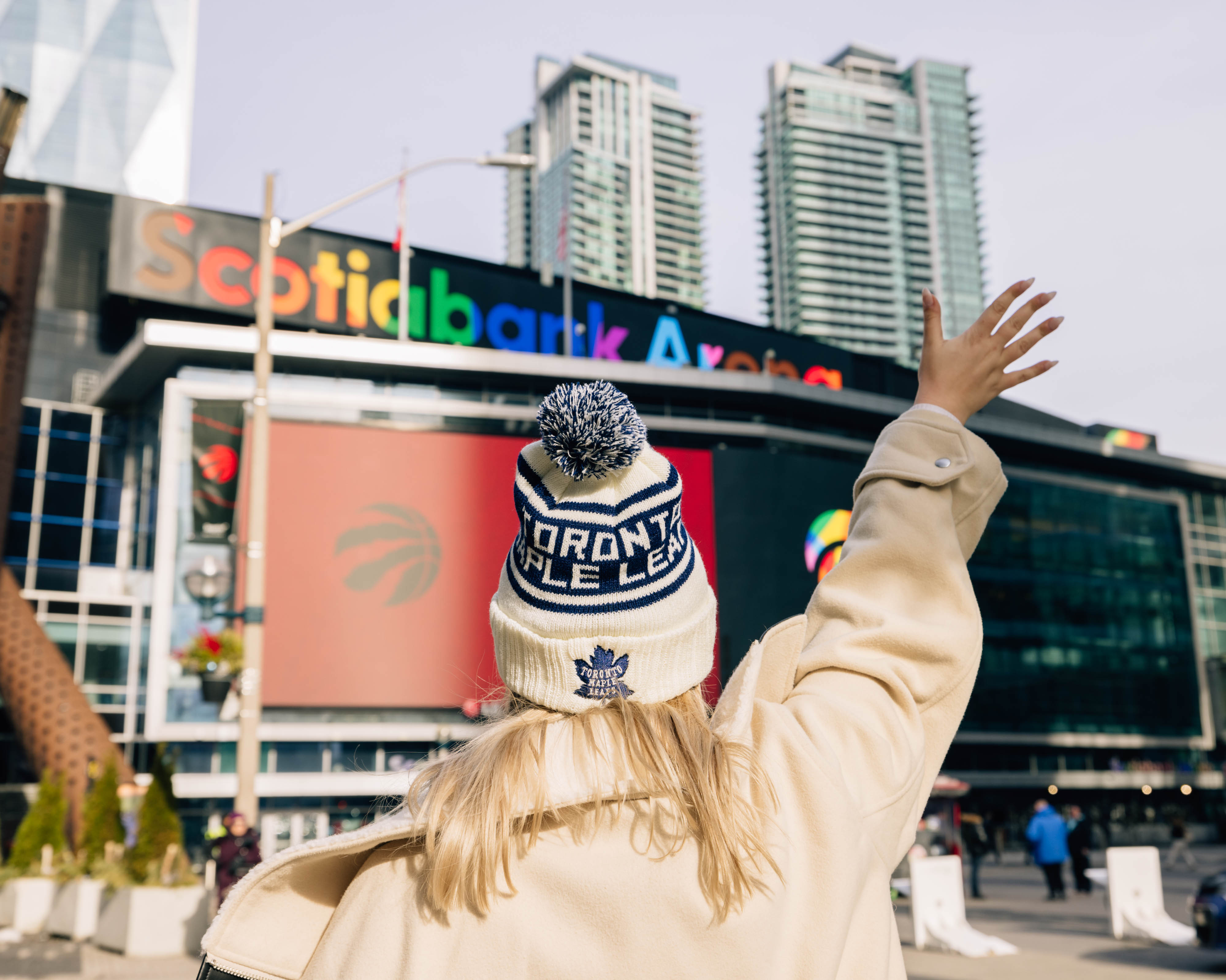 woman waving near hockey stadium