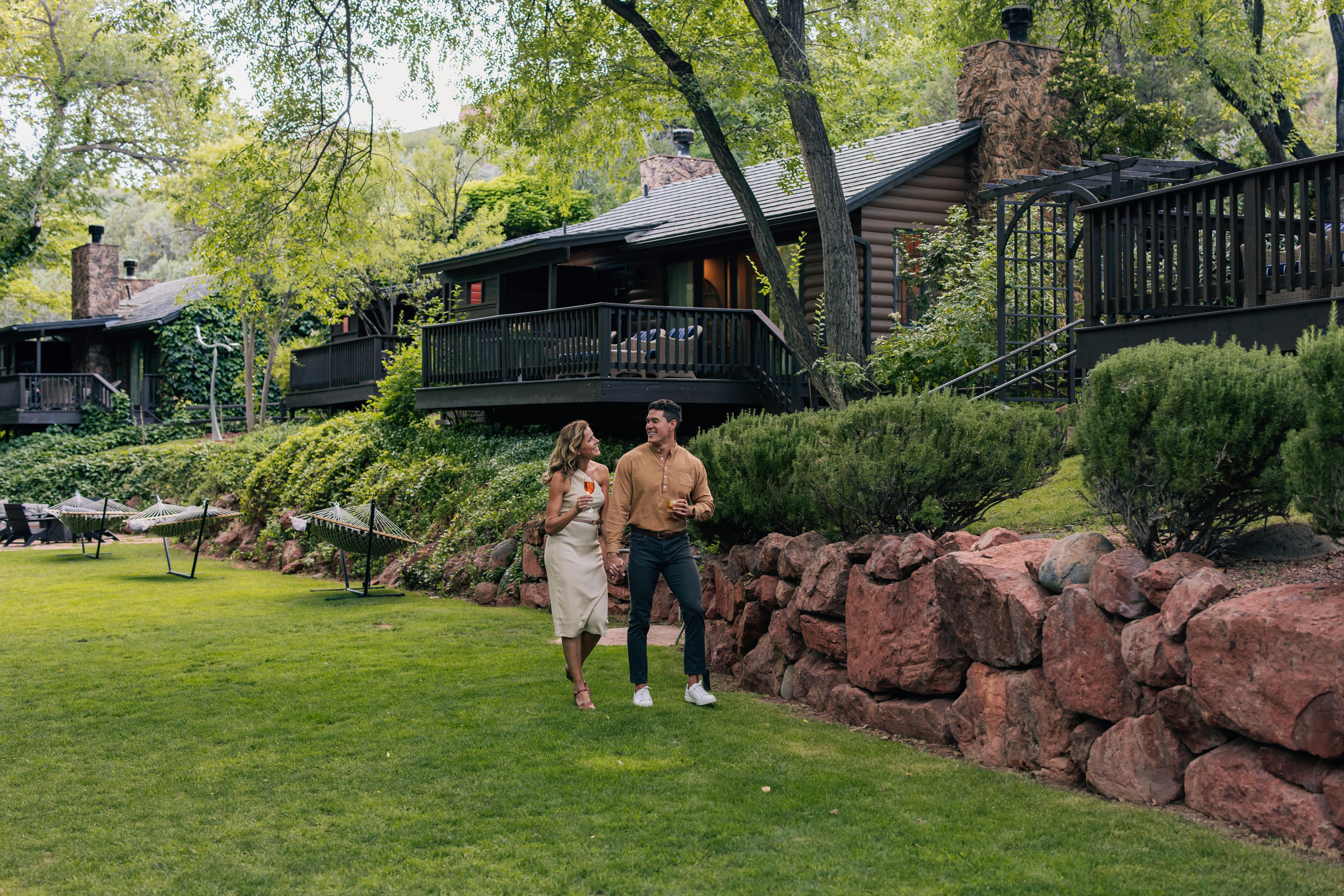 couple walking through a garden while drinking wine