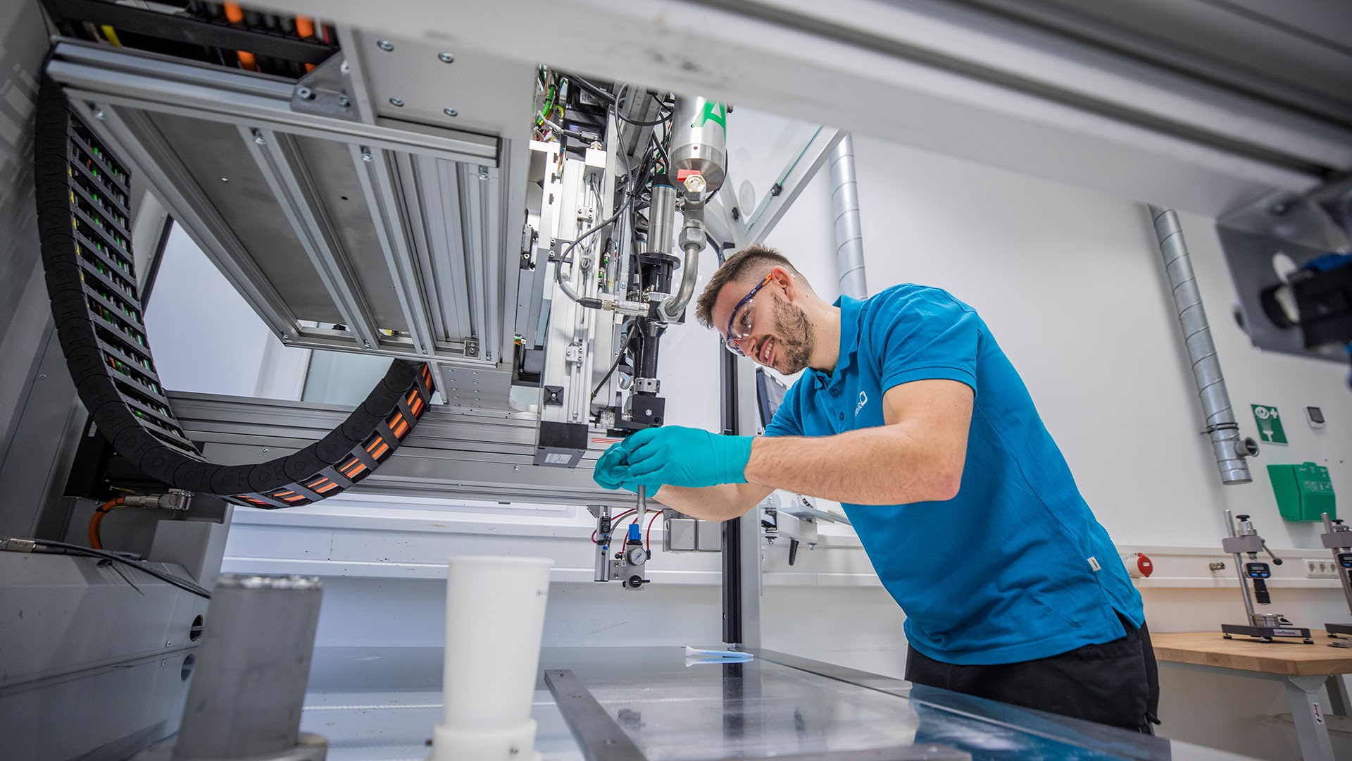 Person working with safety goggles on a machine