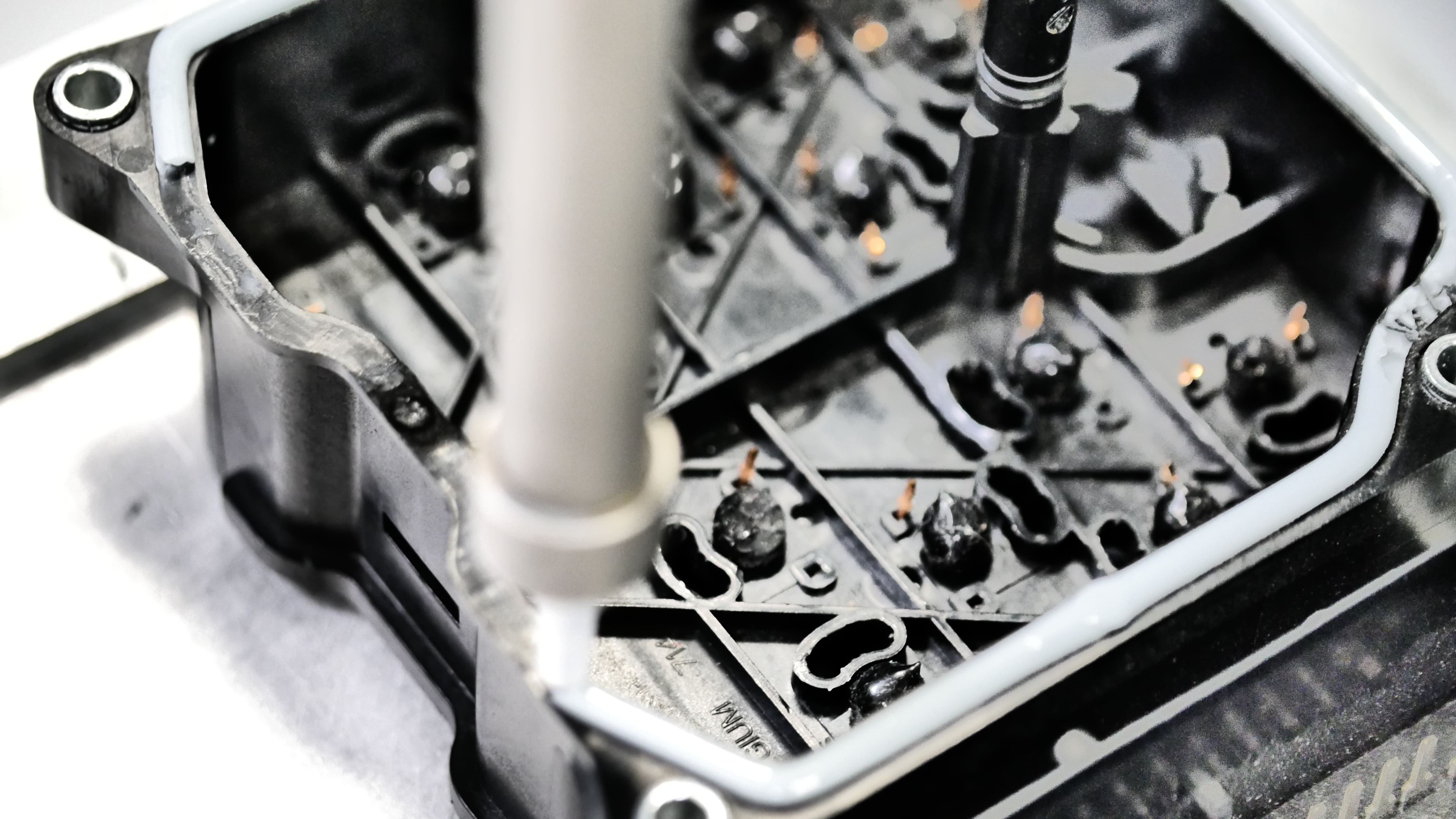 Eine Dichtraupe wird von einer Dosieranlage auf ein Bauteil aufgetragen