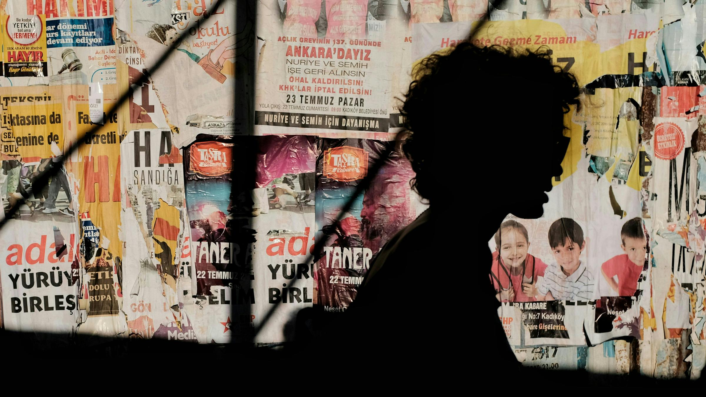 silhouette di donna riccia su sfondo con poster