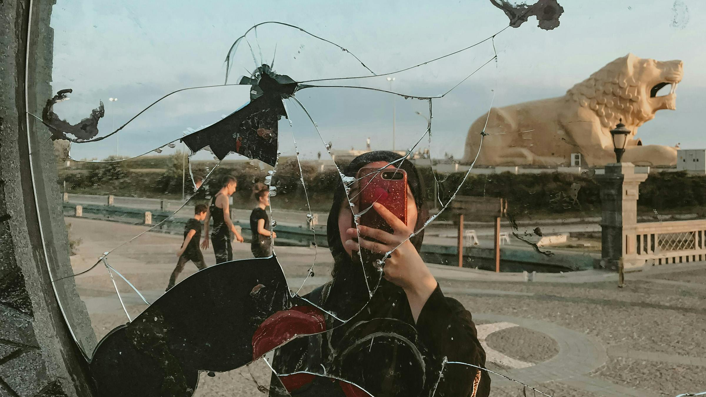 ragazza con il velo che scatta una foto allo specchio rotto