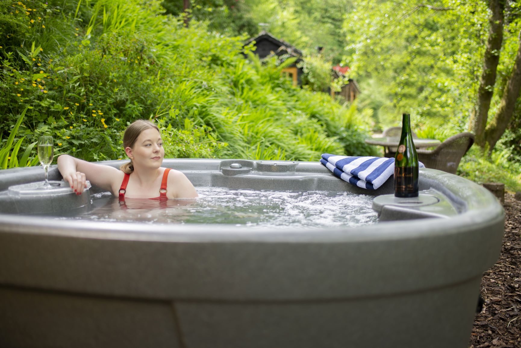 guest enjoying a hot tub with a glass of champagne