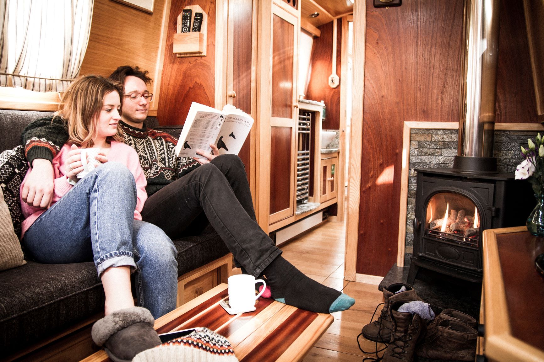 guests enjoying a log-effect gas fire on a beacon park boat