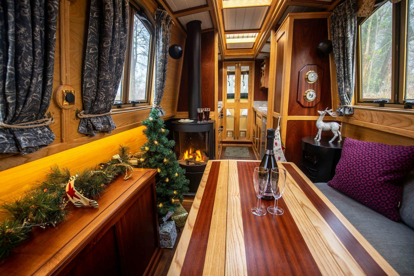 inside of a Christmas decorated canal boat with prosseco on the table