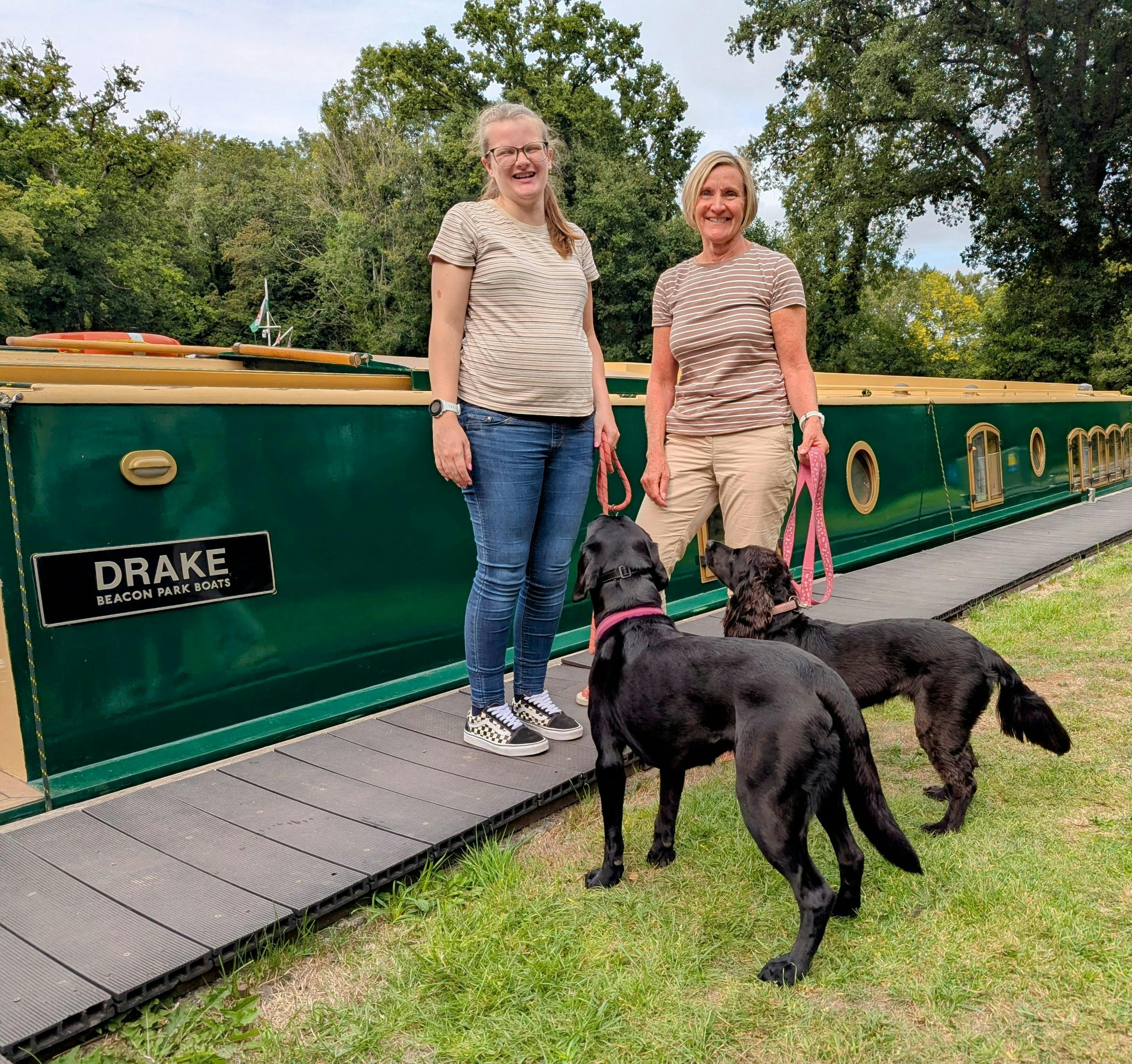 two guests and their two dogs on the canal towpath alongside beacon park boat drake