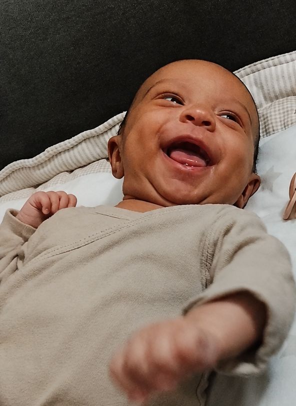 A baby girl is looking at something and smiling