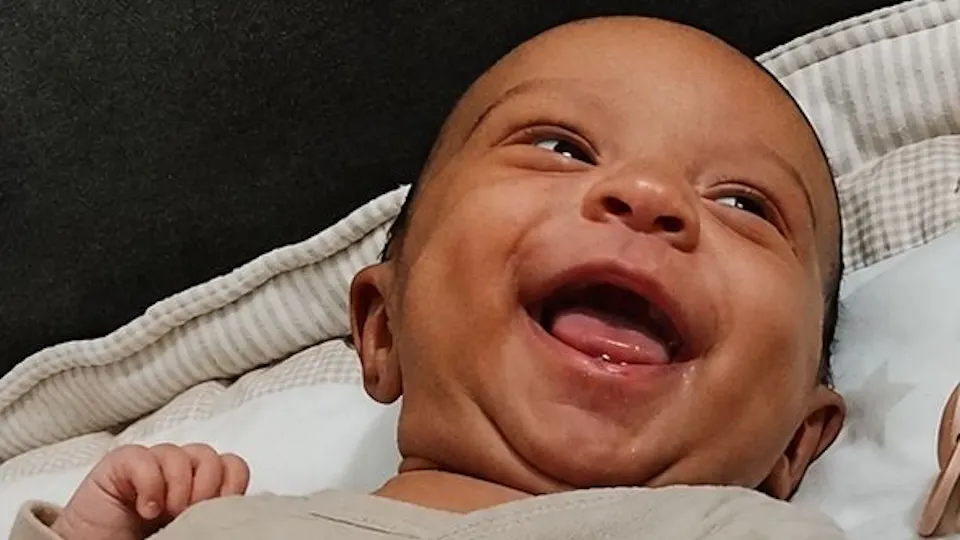 A baby girl is looking at something and smiling