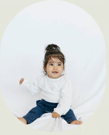 halleli all in white, dark beautiful hair put up in a pigtail