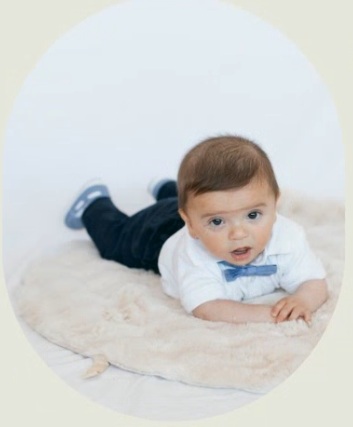 baby neria doing tummy time, wearing white button down and a light blue bow tie