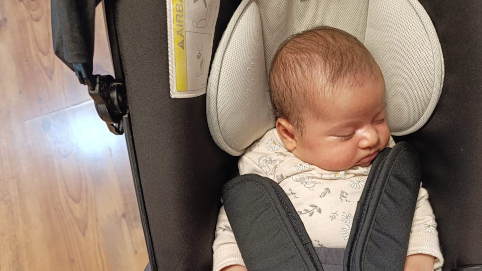 young baby girl in a car seat stroller