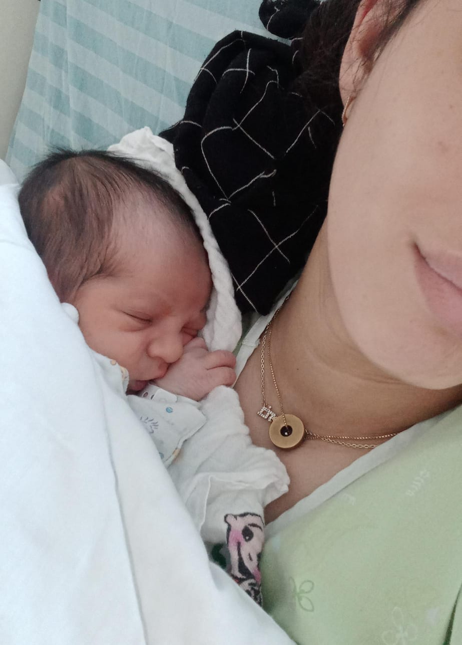 pasgeboren baby ligt op de schouder van zijn moeder